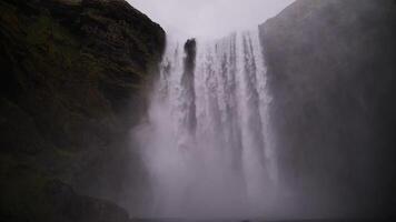 Powerful waterfall flowing between mossy cliffs in Iceland video