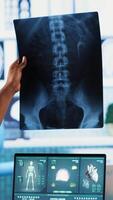 Vertical African american nurse takes notes during consultation with old people, healthcare records with symptoms and other problems. Ensuring an easy recovery plan, clinical setting. Camera B. video