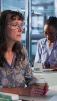 Vertical Physician and patient discuss an x ray and MRI scan focusing on preventive medicine and cancer awareness strategies. Educating a woman on chemotherapy options and preventative care. Camera B. video