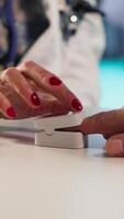 Vertical Female healthcare professional uses an oximeter to measure the oxygen levels for patient at check up, accurate medical advice for recovery. Monitoring pulse and saturation with tool. Camera B. video