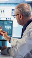 Vertical Radiologist discusses an x ray and MRI scan helping a male patient understand preventative measures, immune system protection and treatment options for cancer prevention. Geriatrics. Camera A. video