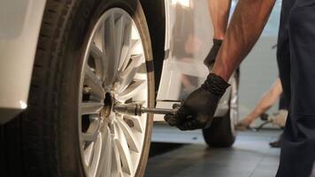 Car mechanic replacing a car tire in garage workshop. Slow motion. Auto service 4 video