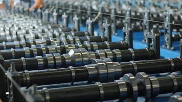 Wide-angle view of aligned rollers on steel sheet forming equipment. video