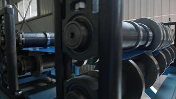 Side view of mechanical rollers guiding metal through production line. video