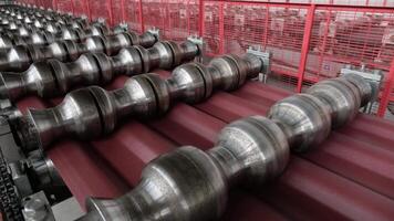 Shaping rollers mounted above a conveyor pressing detailed tile patterns. video