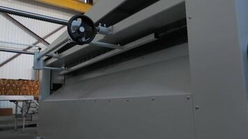 Metal coil feed mechanism in a steel processing unit, showing precision rollers and safety guards. video