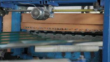 Shiny steel coil moving through synchronized roller system for sheet flattening and forming. video