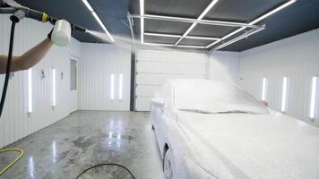 Empty detailing garage with bright LED lights and foam on the floor after car wash. video