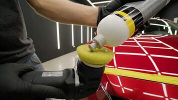 Detailer using orbital buffer for car body paint correction in workshop. video