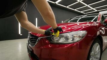 Polishing front part of a red vehicle to restore surface gloss. video