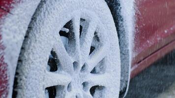 Detailed view of foam buildup on car rim and fender during exterior wash. video