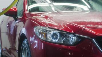 Front view of detailed red vehicle with clean illuminated headlights. video