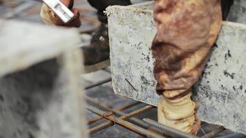 Worker securing formwork on rebar grid with hammer video