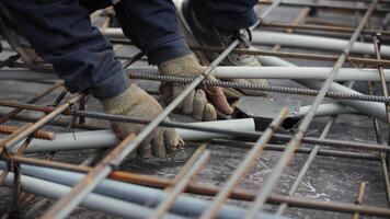 Worker connecting electrical conduit pipe in rebar framework video