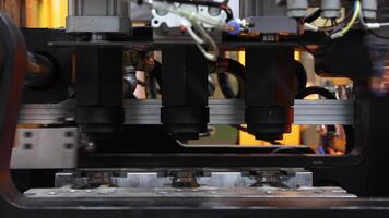 Close up of plastic PET bottle preform heating process in industrial manufacturing machine. Automated industrial PET bottle machine. Robotic system automation in high speed plastic bottle production video