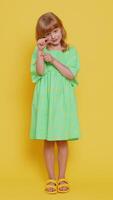 Child girl showing a little bit gesture with sceptic smile showing minimum sign measuring small size video