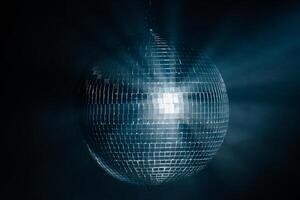 Disco ball reflecting dynamic rays of light against a black background. Perfect for creating a vibrant and energetic atmosphere at parties and events photo