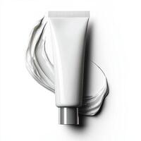 Soft face cream oozing from tube, gently spreading on white. photo