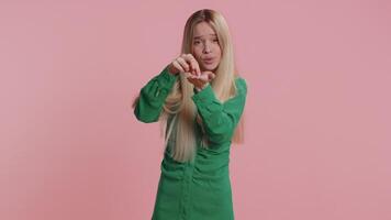 Young girl showing a little bit gesture with sceptic smile showing minimum sign measuring small size video