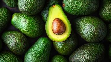 Close up View of Ripe Green Avocados With One Sliced in Half Showcasing Its Seed photo