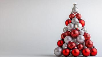 Festive Christmas Tree Crafted From Red and Silver Ornaments Against a Clean White Backdrop photo