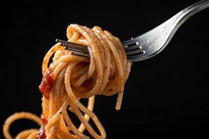 close-up Tasty spaghetti wrapped around fork on black background -generated by ai photo