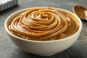 Close-up of a bowl of dulce de leche forming waves on top, HDR image, generated by ai photo