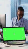 Vertical Senior medic consulting ill man in cabinet with isolated mockup screen, checking the hospital records to do another x ray scan interpretation. Old patient discuss with his physician. Camera B. video