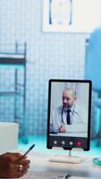 Vertical Nurse discussing with patients while on videocall with an expert, receiving professional diagnosis and different advice for recovery. Doctor supporting clients via internet conference. Camera B. video