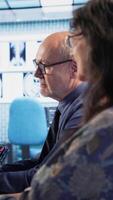 Vertical African american assistant and patients engage in medical checkup with hospital records and x ray results files to find accurate treatment for wellness and recovery. Healthcare practices. Camera A. video