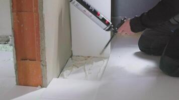 Worker applying polyurethane expanding foam between insulation panels and wall video