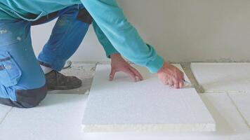 Professional worker placing square styrofoam panels on a floor video