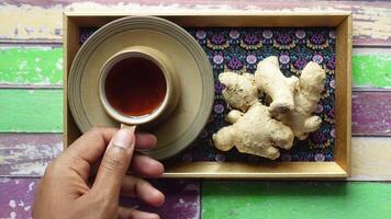 Enjoying ginger tea on a colorful wooden table video