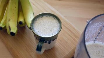 Healthy banana smoothie preparation in a cozy kitchen setting video