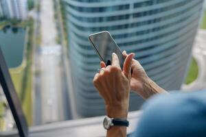 A person is skillfully using a smartphone in a modern urban environment with digital tools photo