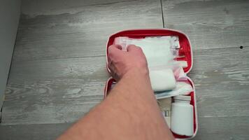 A person's hand is holding a red suitcase with a white container video