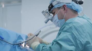 Close-up of surgeon using modern tools in a brightly lit operating room. video