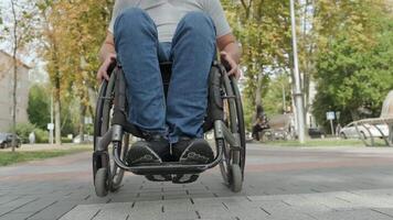 Man with a disability in a wheelchair crossing a pedestrian path in an urban setting. video