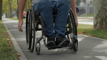 Rear view of a person in a wheelchair rolling independently on a dedicated path. video