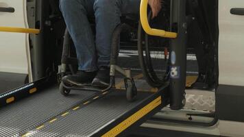 Person with disabilities using powered lift to enter adapted transport. video