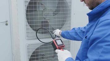 The technician uses a digital camera to check the clogging of the heat exchanger video