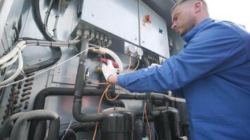 The technician checking power lines of the heat exchanger with current clamps 4 video