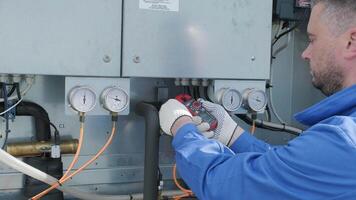 The technician checking power lines of the heat exchanger with current clamps 8 video