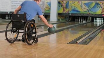 Two young with disability men in wheelchairs playing bowling in the club 19 video