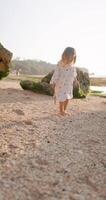 Cute little girl play on ocean beach with warm sunlight video