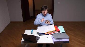 Stressed office worker shouting on phone while pointing at documents video