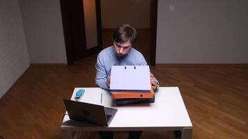 Office worker looking stressed at binders sitting at desk video