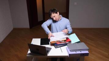 Office worker searching documents while talking on phone at night video