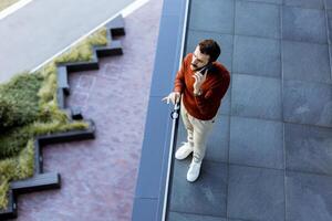 A man standing on a balcony talking on a cell phone photo