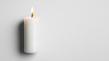 Lit White Pillar Candle On Gray Background photo